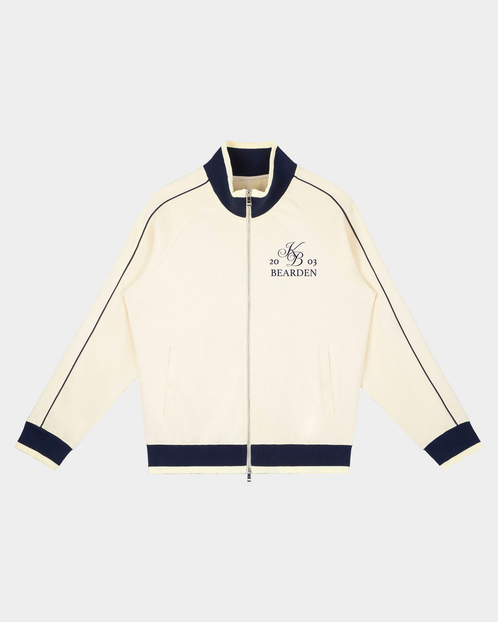 Kaleb A. Bearden Home Blues Track Jacket showing navy blue fabric with white stripe details and front zipper closure.