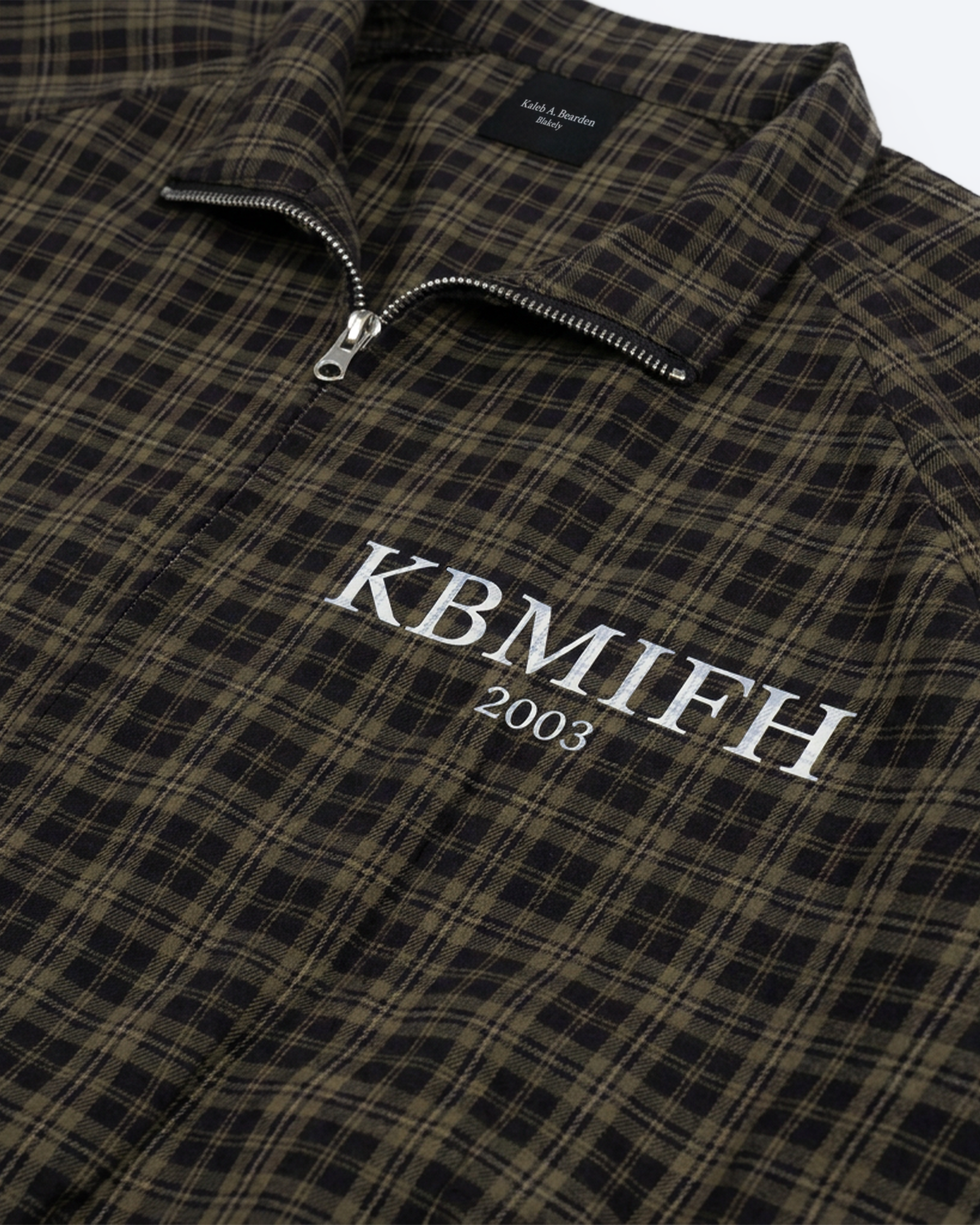 Olive plaid full-zip track jacket by ODMPOD featuring a stylish pattern, ribbed cuffs, and a comfortable athletic fit.