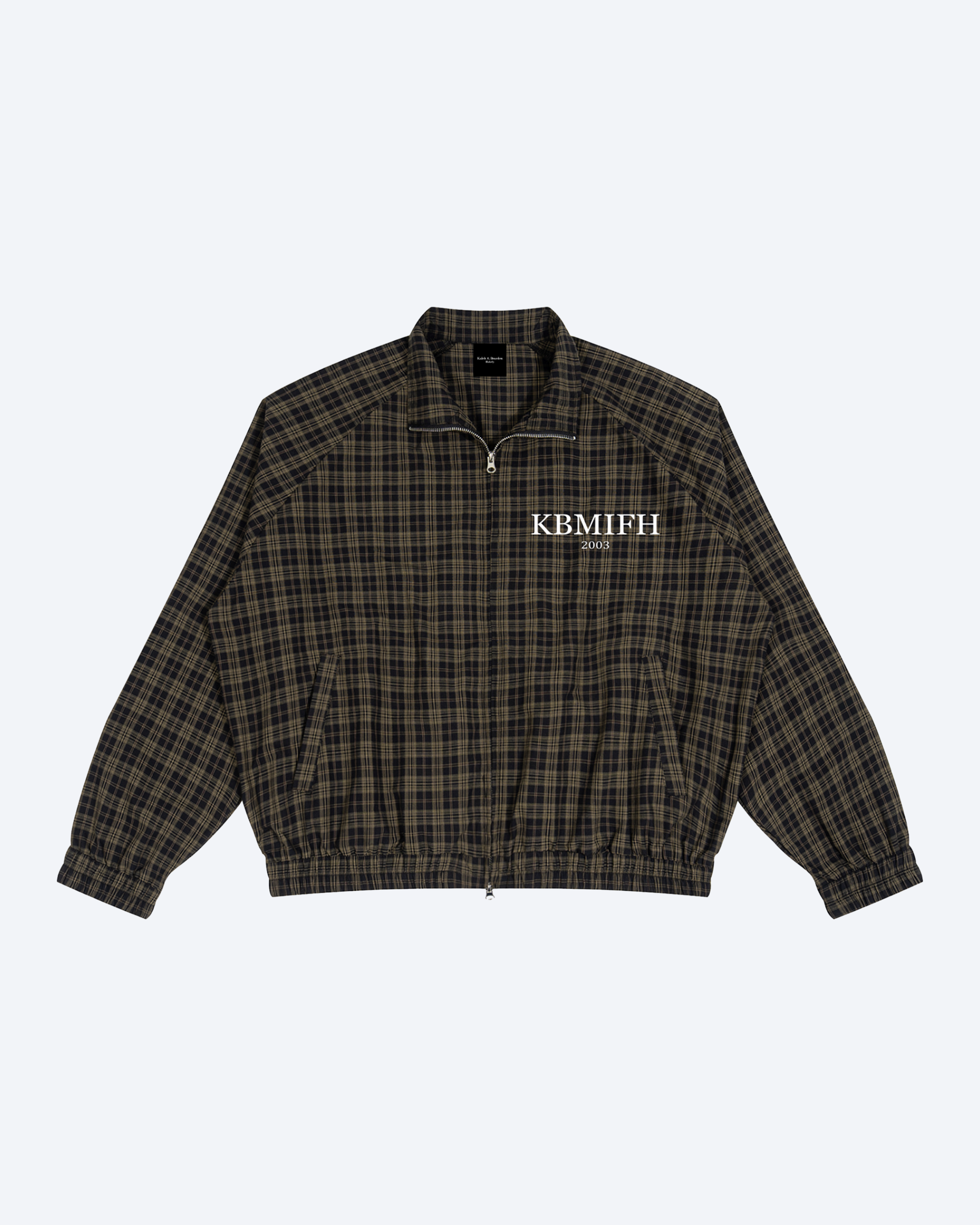 Olive plaid full-zip track jacket by ODMPOD with ribbed cuffs and collar, shown hanging on a hanger.