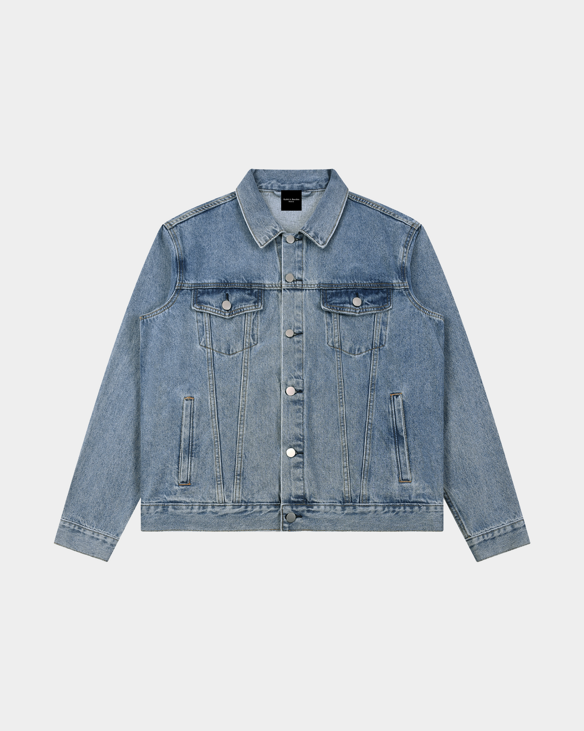 Dark blue ODMPOD heavyweight denim trucker jacket with button closure and classic collar, displayed on a hanger.