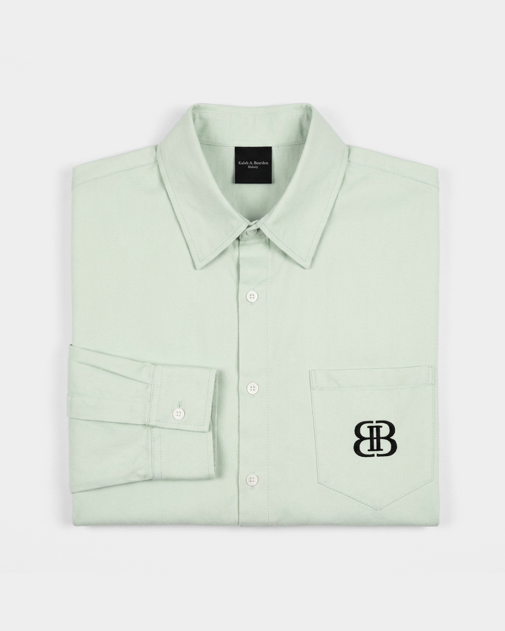 ODMPOD BB Mint Drop Shoulder Shirt displayed on a hanger, featuring a relaxed fit and mint green color with drop shoulder design.