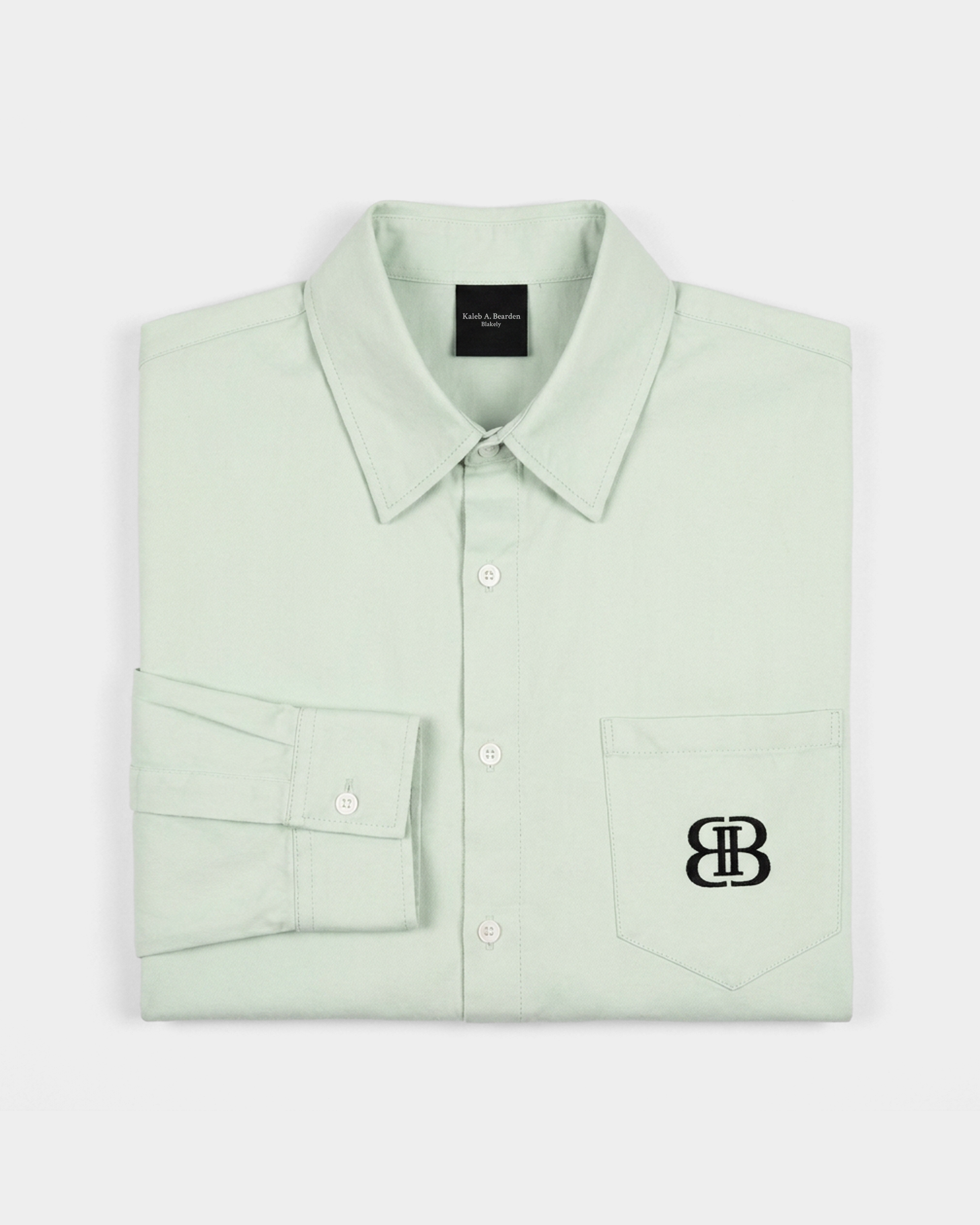 ODMPOD BB Mint Drop Shoulder Shirt displayed on a hanger, featuring a relaxed fit and mint green color with drop shoulder design.