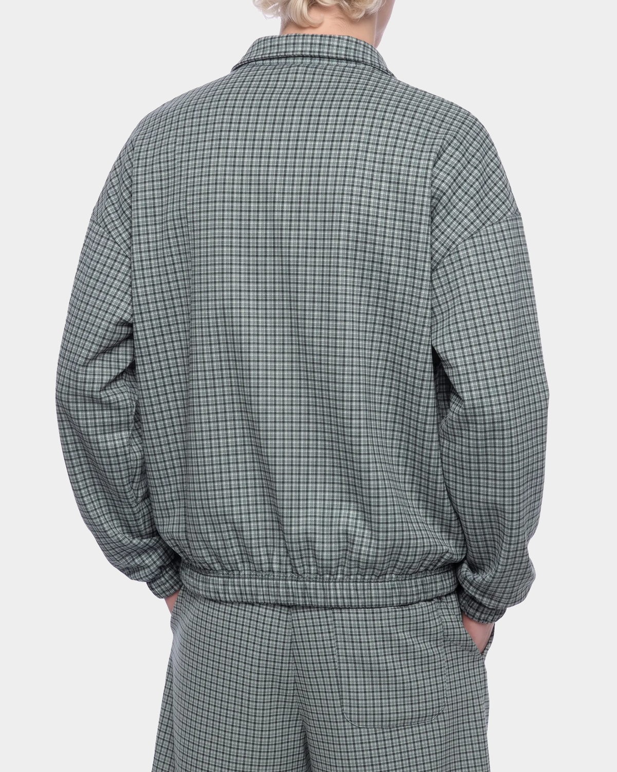 ODMPOD BB Plaid Blouson jacket with front zipper and checkered pattern, shown in a stylish casual look.
