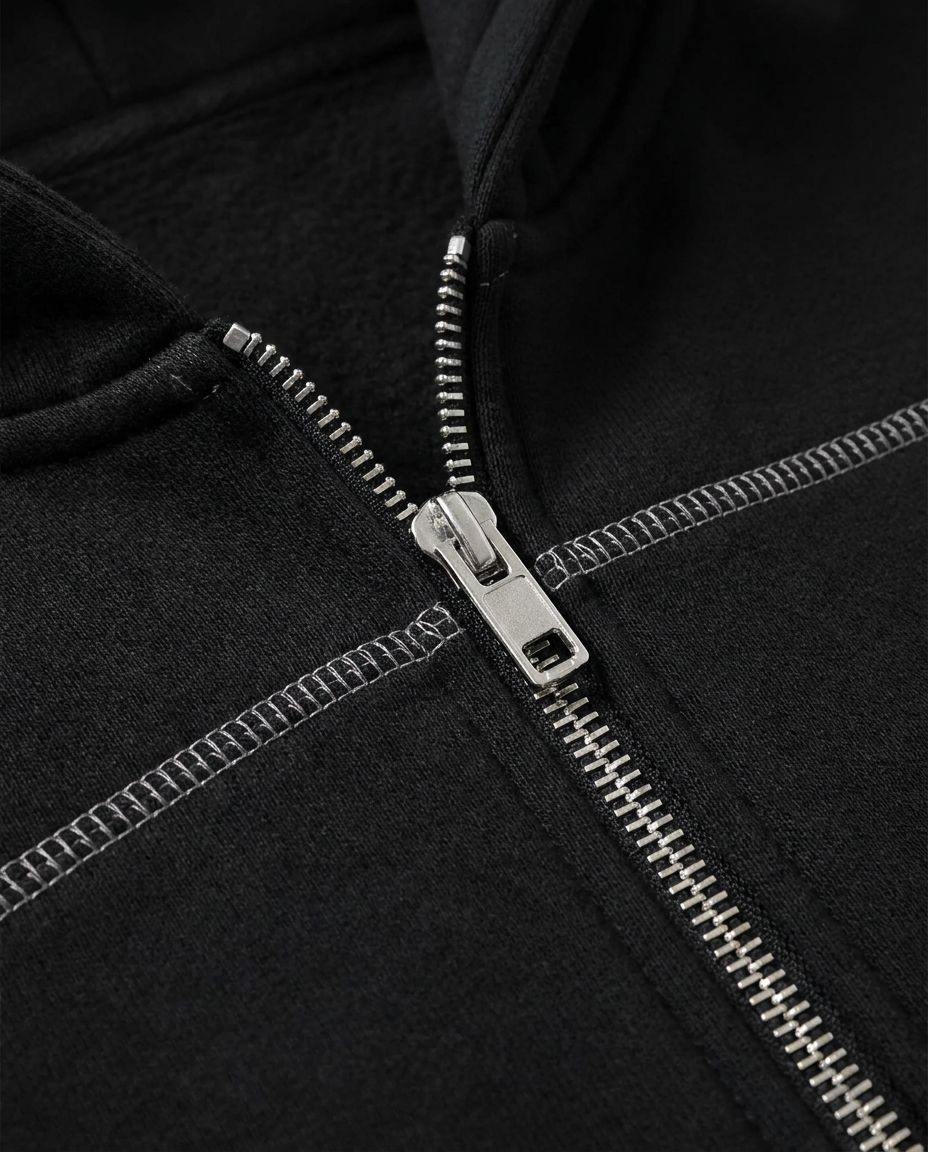 Close-up of ODMPOD Origin Monogram Contrast Hoodie showing contrast stitching and embroidered logo details.