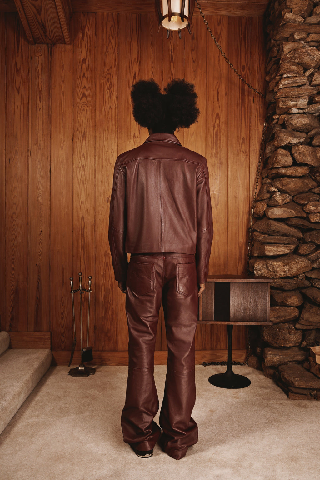 Maroon strapped jacket by Kaleb A. Bearden featuring a stylish design and adjustable straps, shown on a hanger.
