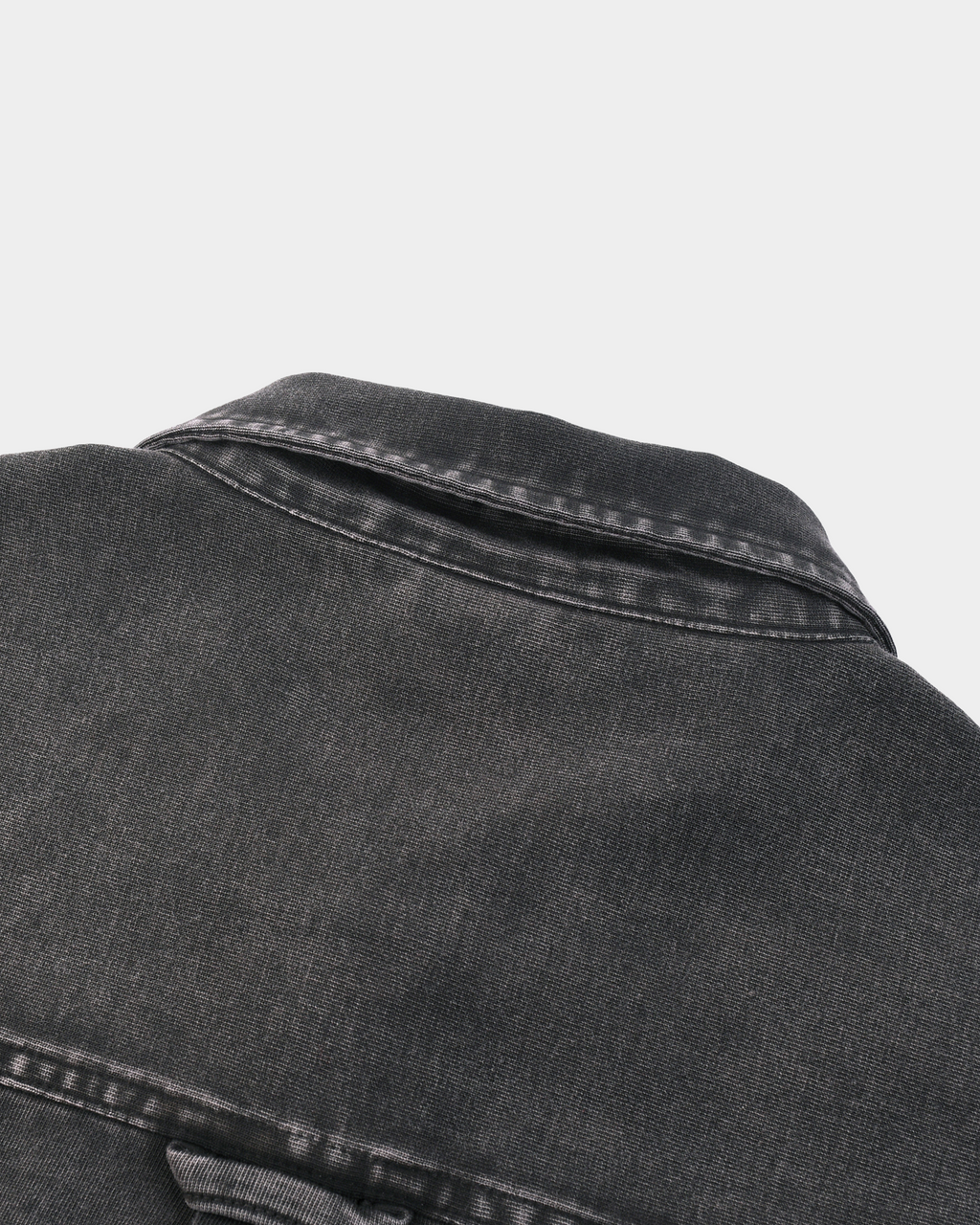 Kaleb A. Bearden Monogram Washed Denim Overshirt hanging on a wooden hanger, showcasing its casual denim style and monogram details.