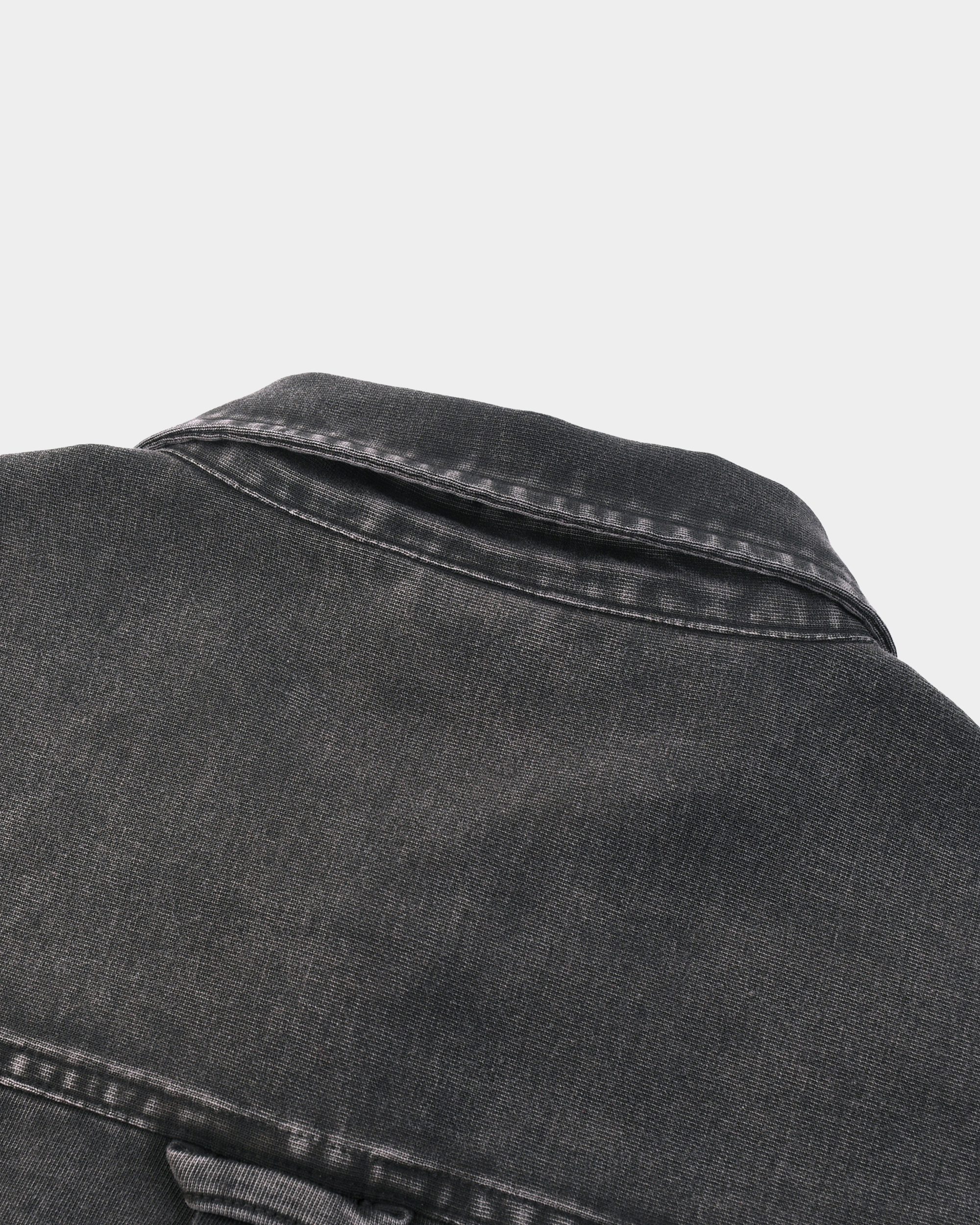 Kaleb A. Bearden Monogram Washed Denim Overshirt hanging on a wooden hanger, showcasing its casual denim style and monogram details.